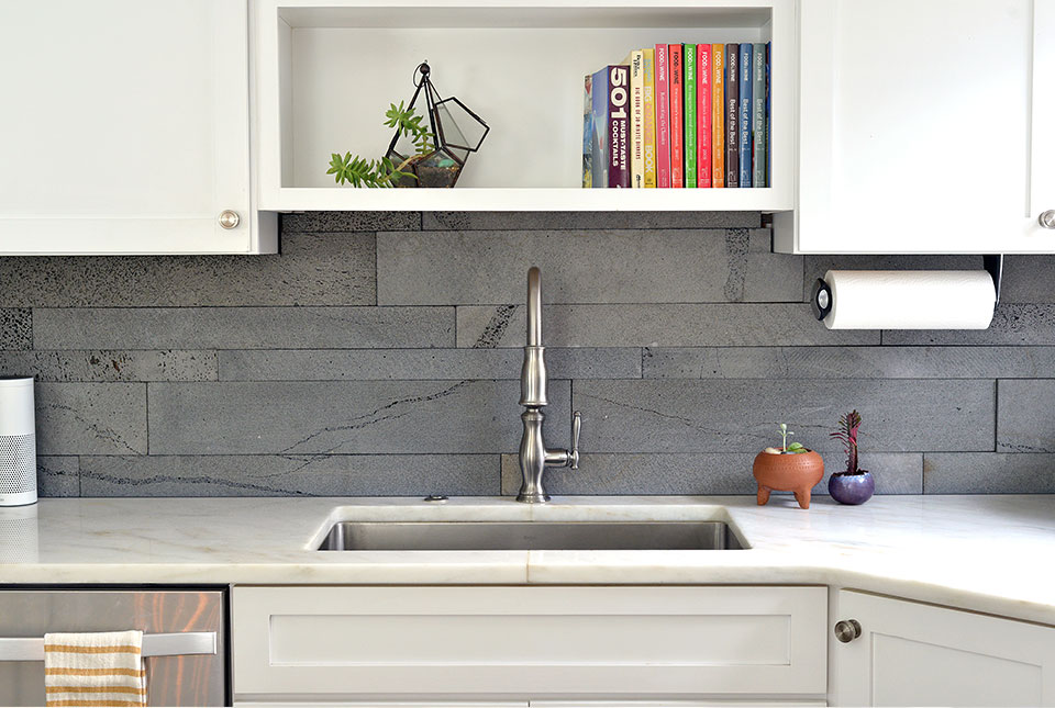 Norstone PLANC large format tile in Platinum color used the backsplash of a modern kitchen with white countertops and white cabinets.